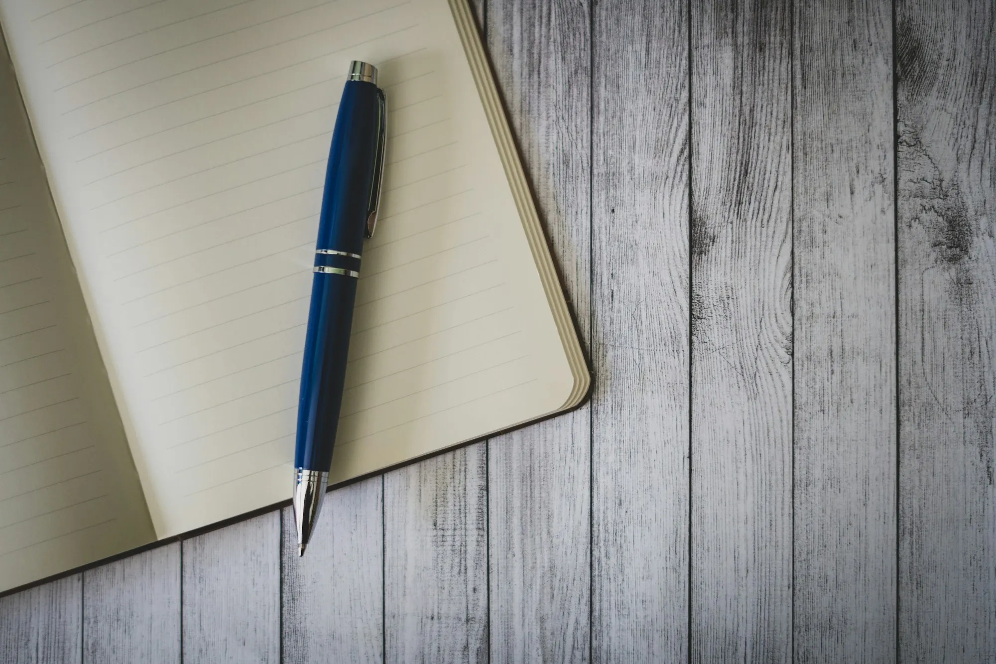 Notebook and pen on a gray wooden table