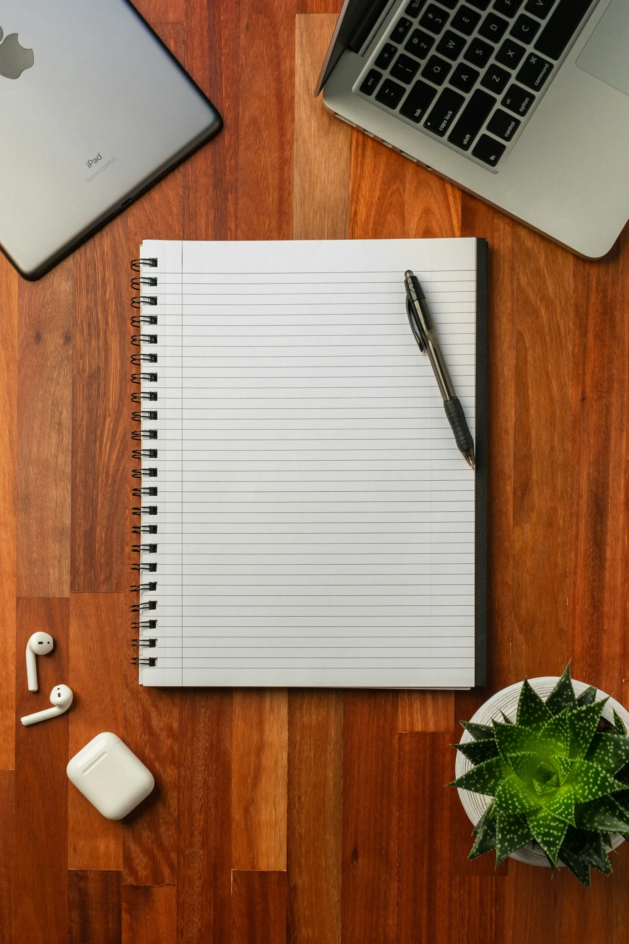 Lined notebook and pen on a wooden desk