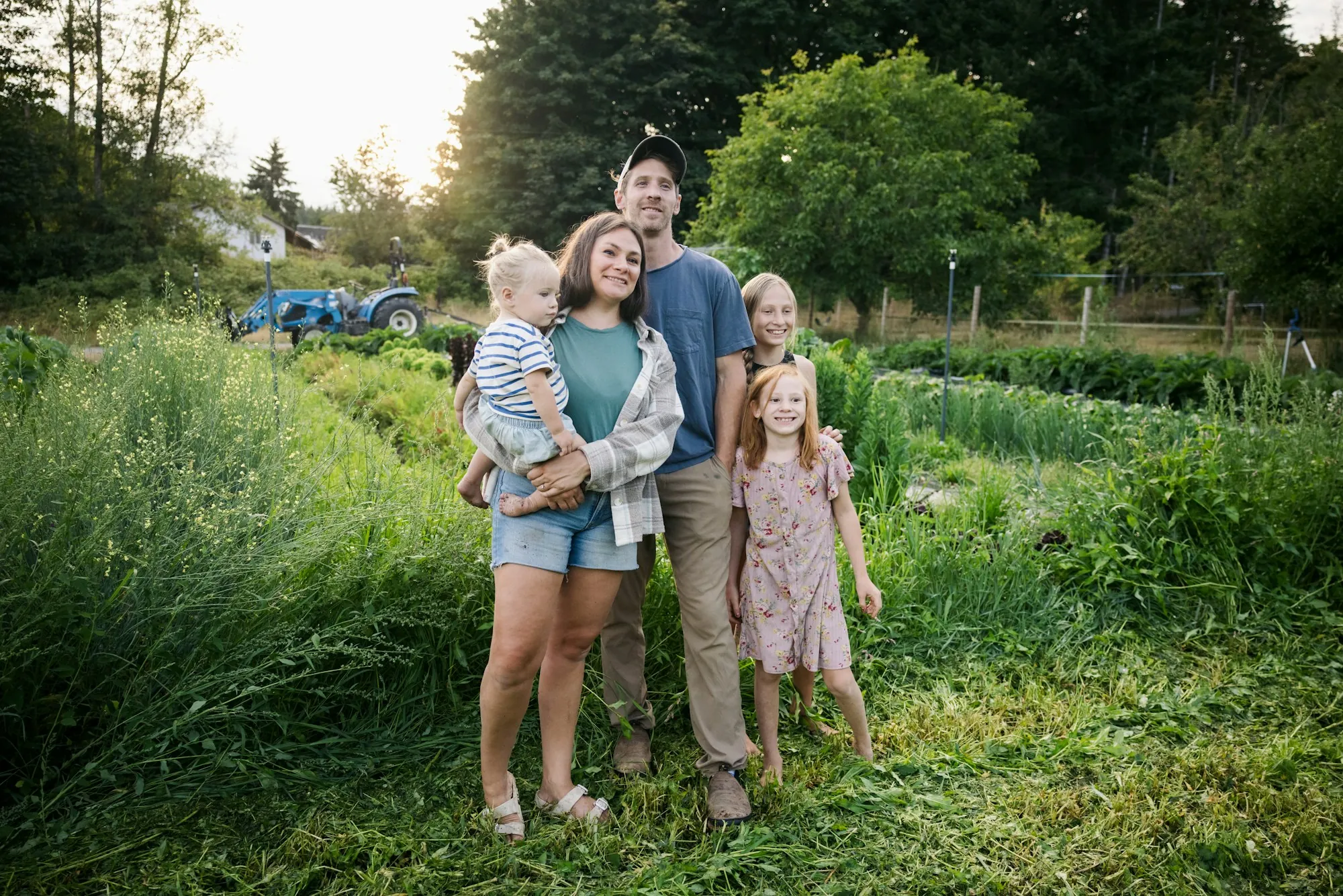 Parents and three children standing in a green field
